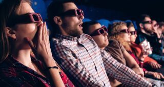 Movie goers gasping in shock as something exciting happens on the screen